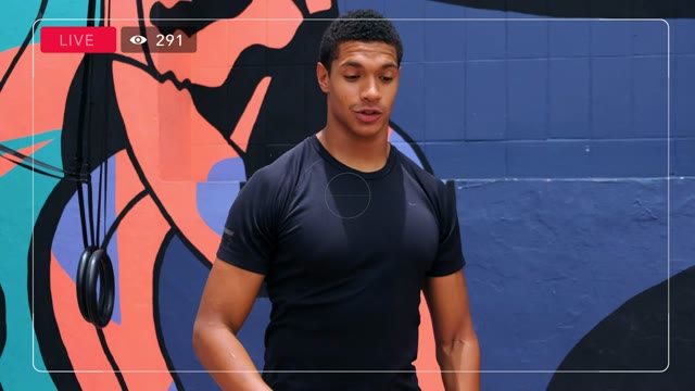 Man Livestreaming Near Mural